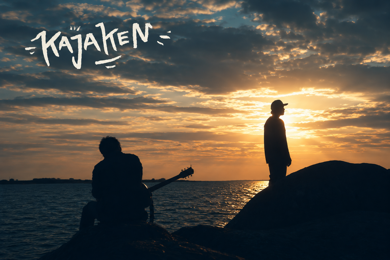 Kajaken – silhuetter mot solnedgången vid vattnet, en med gitarr och en stående på en klippa